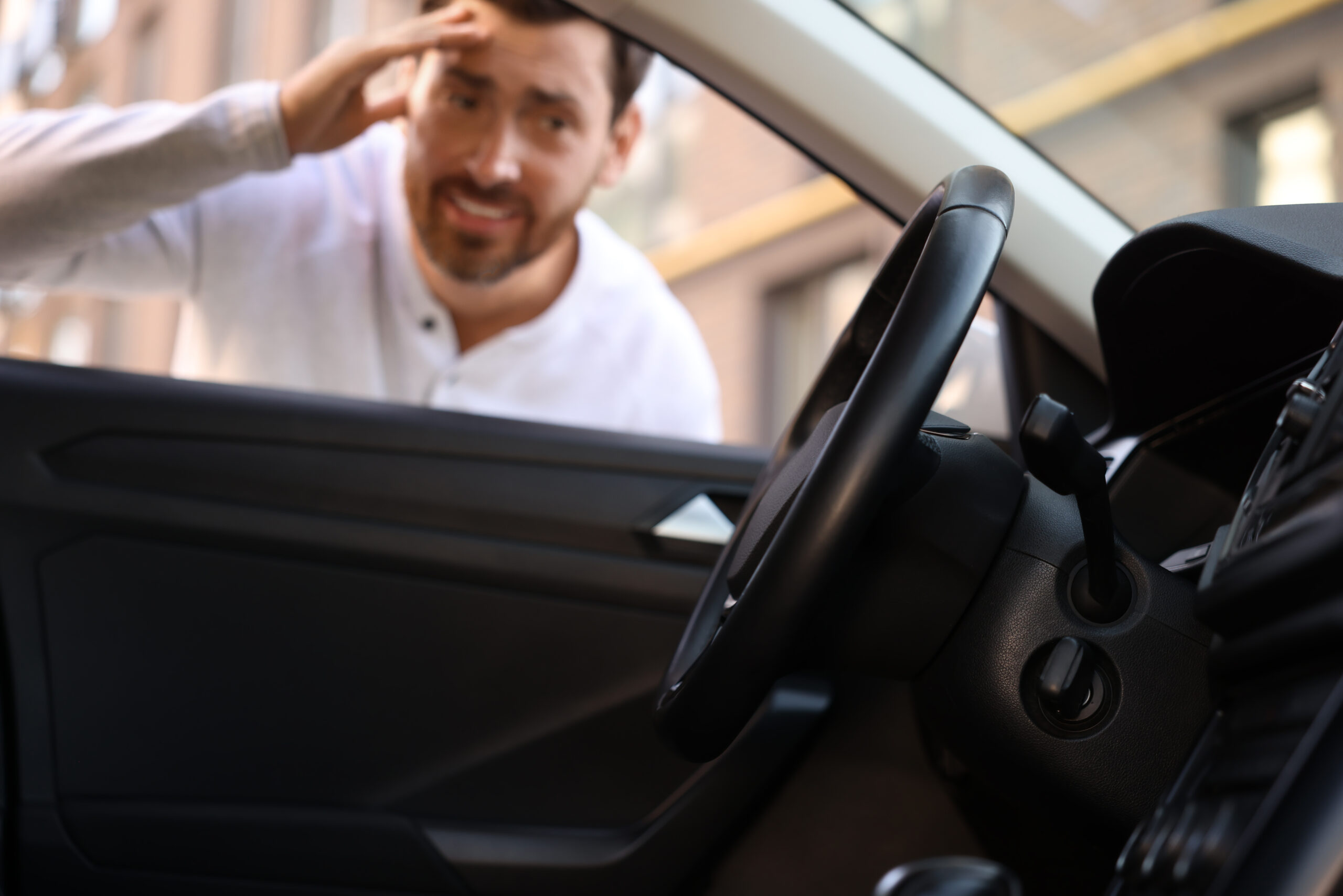Automobile lockout key forgotten inside selective focus Emotional man looking through car window